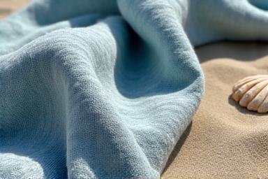 Organic cotton beach towel with natural dyes on sand